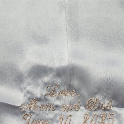 A white cloth with the words `` love mom and dad '' embroidered on it.