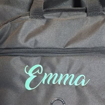 A black bag with the name emma embroidered on it