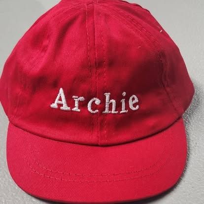 A red hat with the name archie embroidered on it