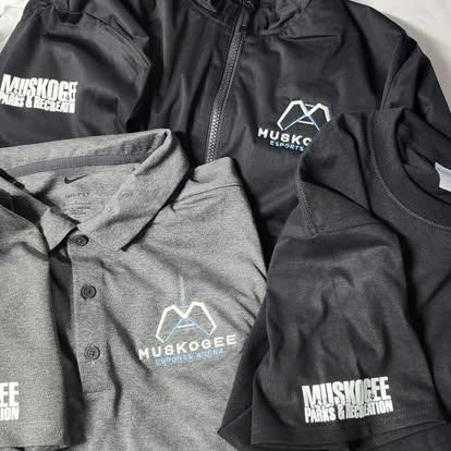A group of muskoogee shirts and jackets are sitting on top of each other on a table.