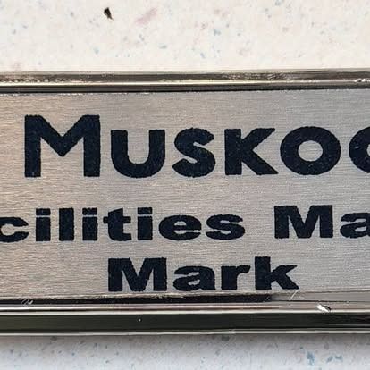 A close up of a name tag with the name mark on it