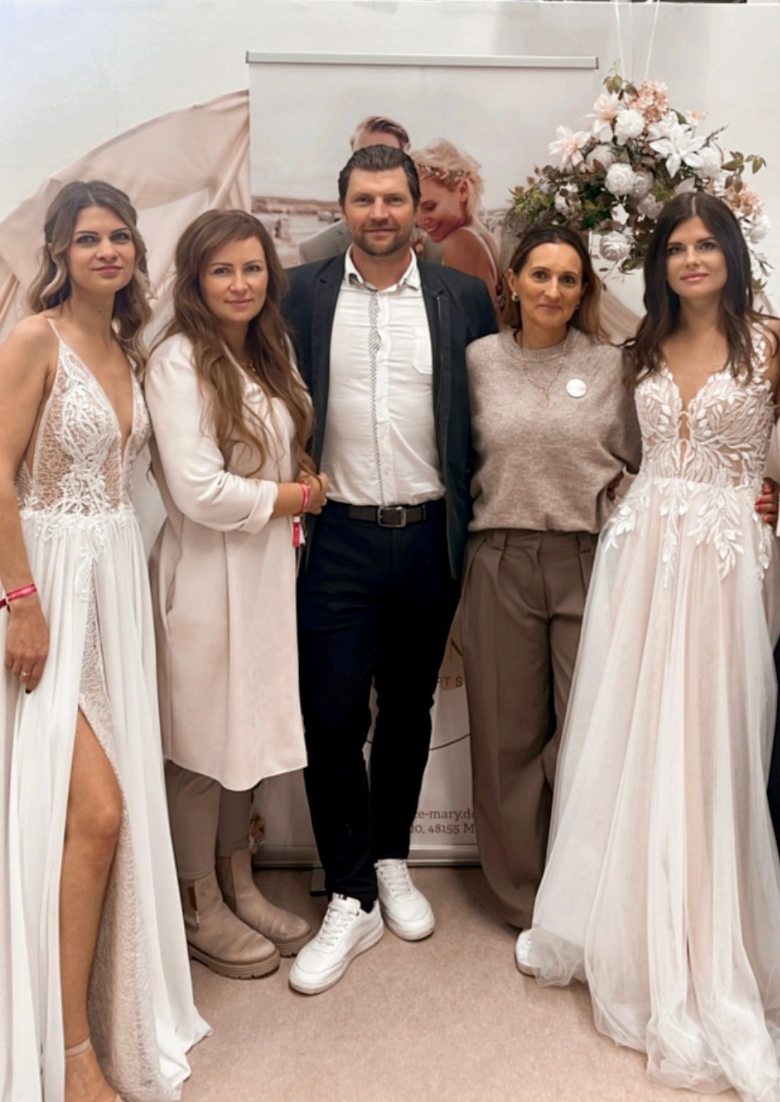 Eine Gruppe von Menschen in Brautkleidern posiert für ein Foto.