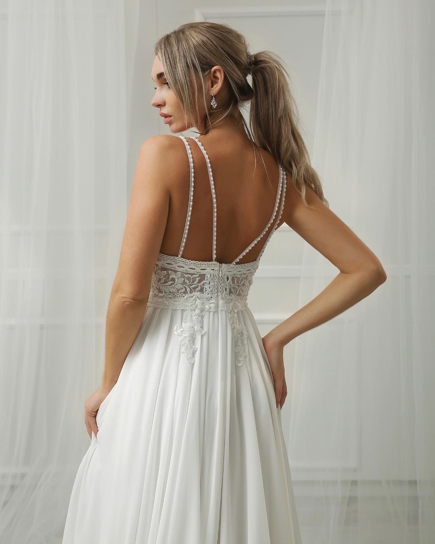 Der Rücken einer Frau in einem weißen Hochzeitskleid.