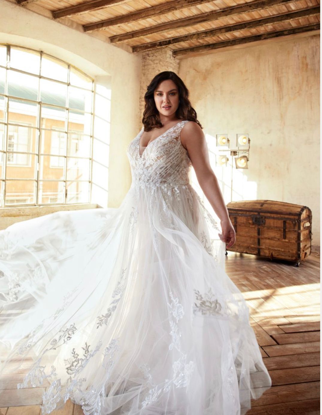 Eine Frau in einem weißen Brautkleid steht in einem Raum.