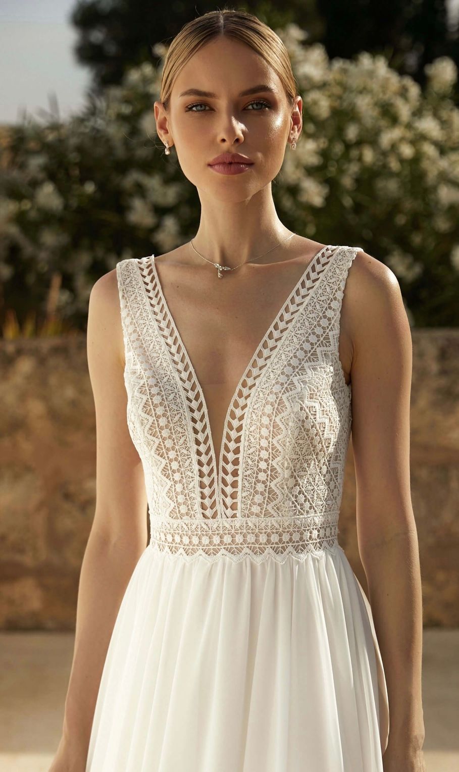 Eine Frau trägt ein weißes Hochzeitskleid mit tiefem Ausschnitt.