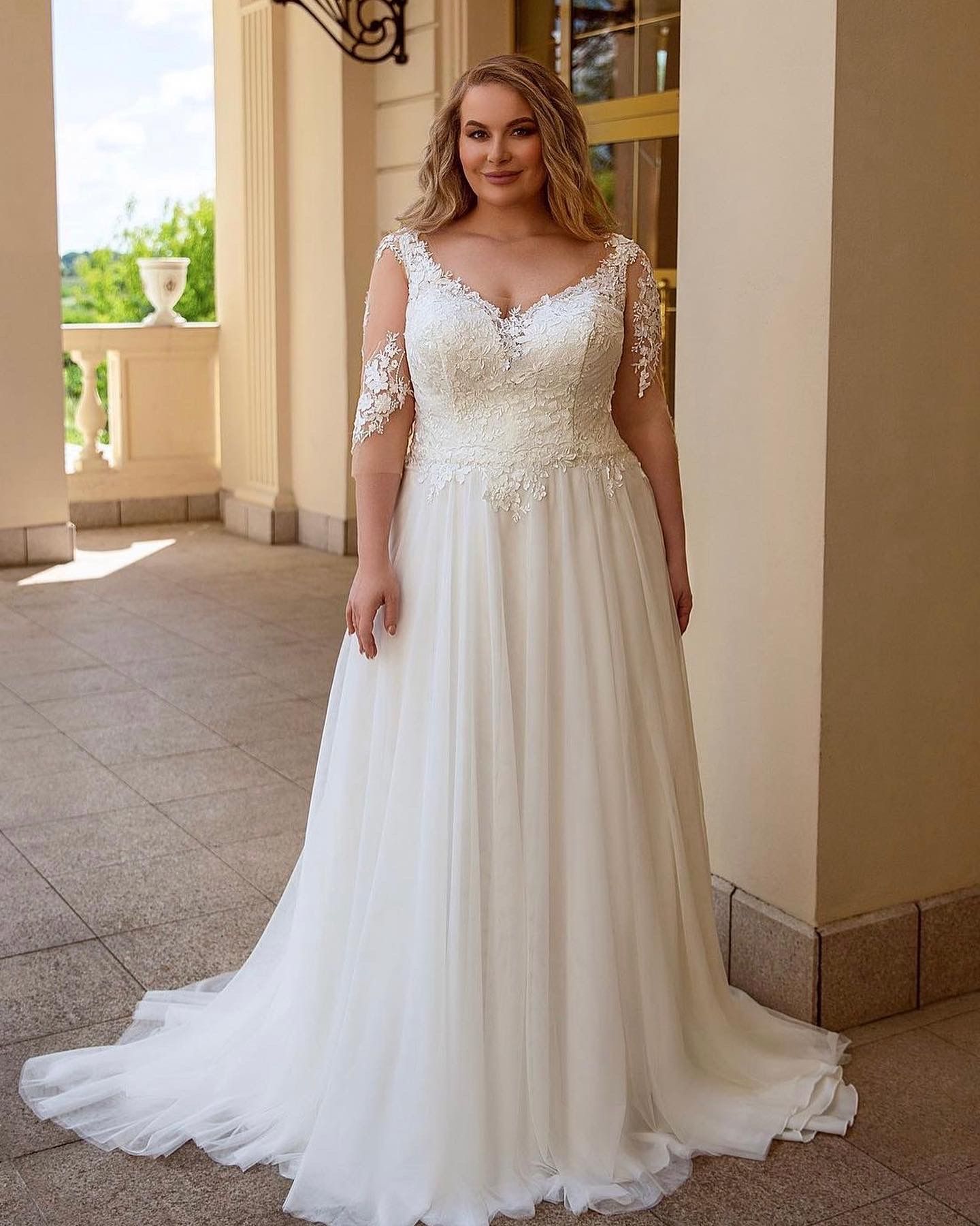 Eine Frau mit Übergröße trägt ein weißes Hochzeitskleid.