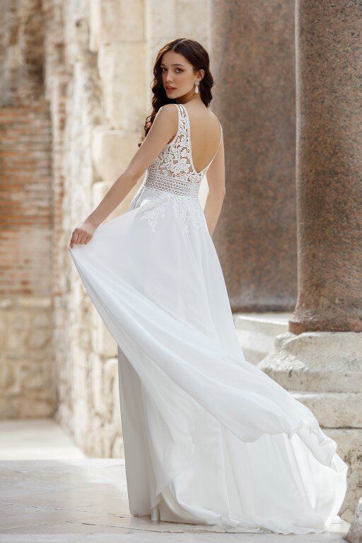 Zu sehen ist der Rücken einer Frau in einem weißen Brautkleid.