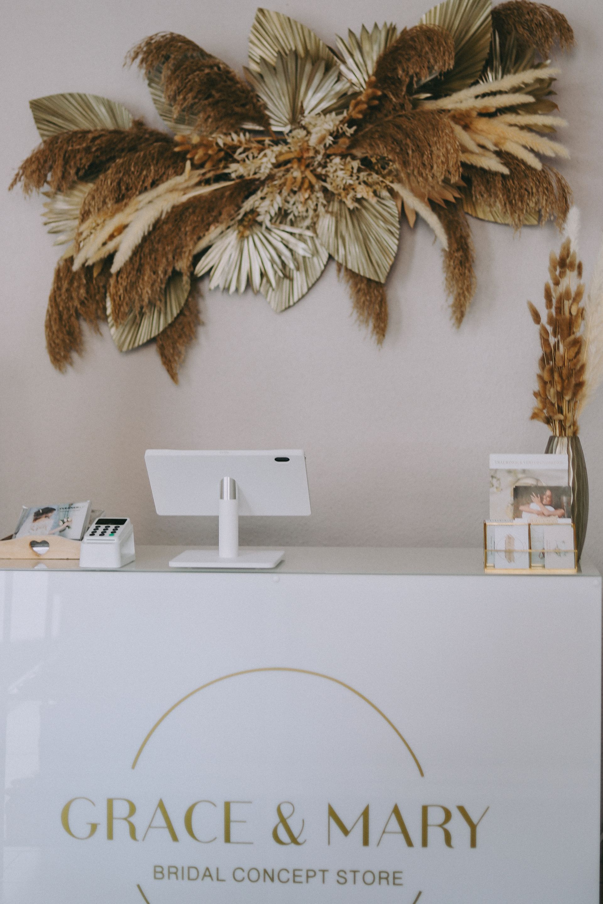 Ein Grace and Mary Bridal Concept Store mit Blumen an der Wand