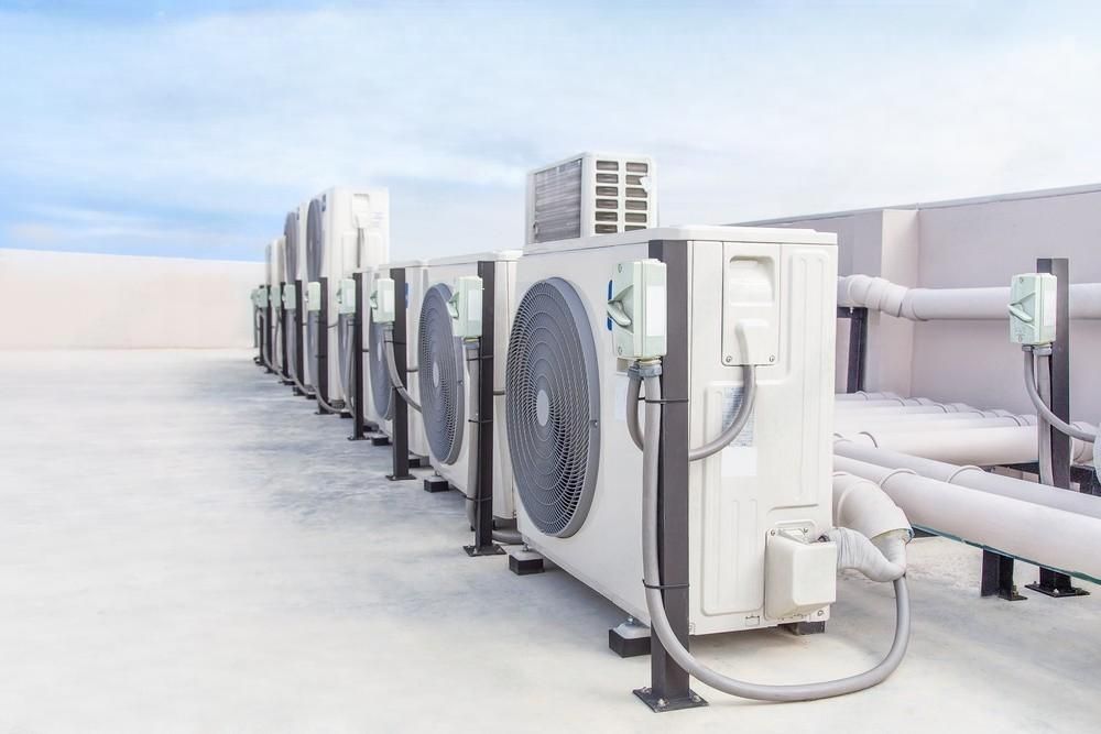 a row of air conditioners on the roof of a building .