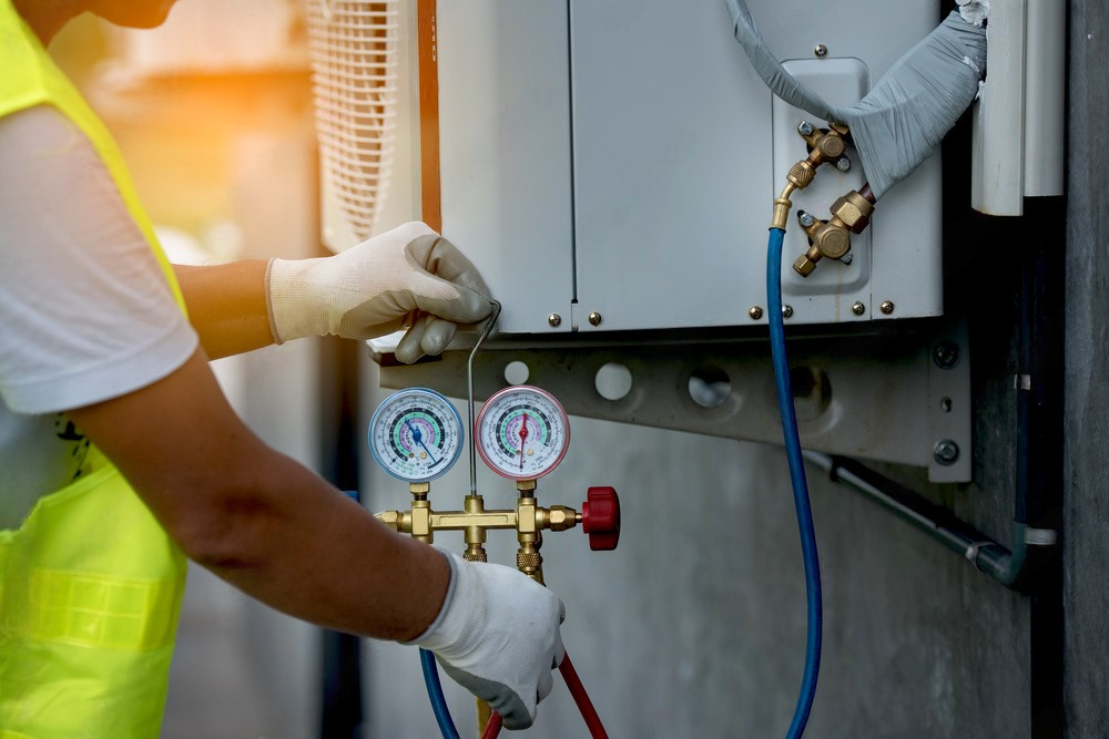 a man is working on an air conditioner outside of a building .