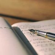Fountain pen resting on handwritten notes in an open notebook