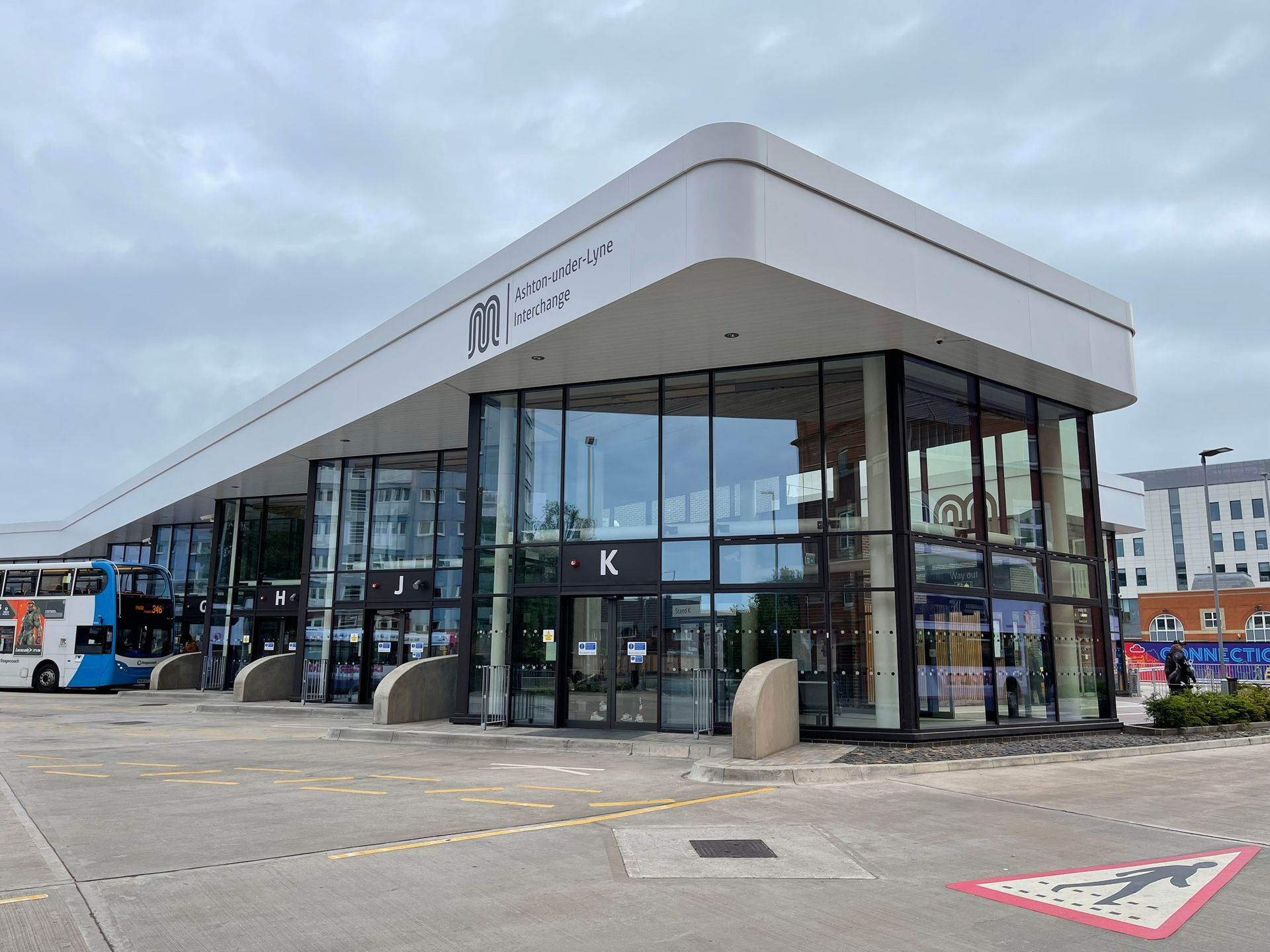 A large building with a lot of windows and a bus parked in front of it.