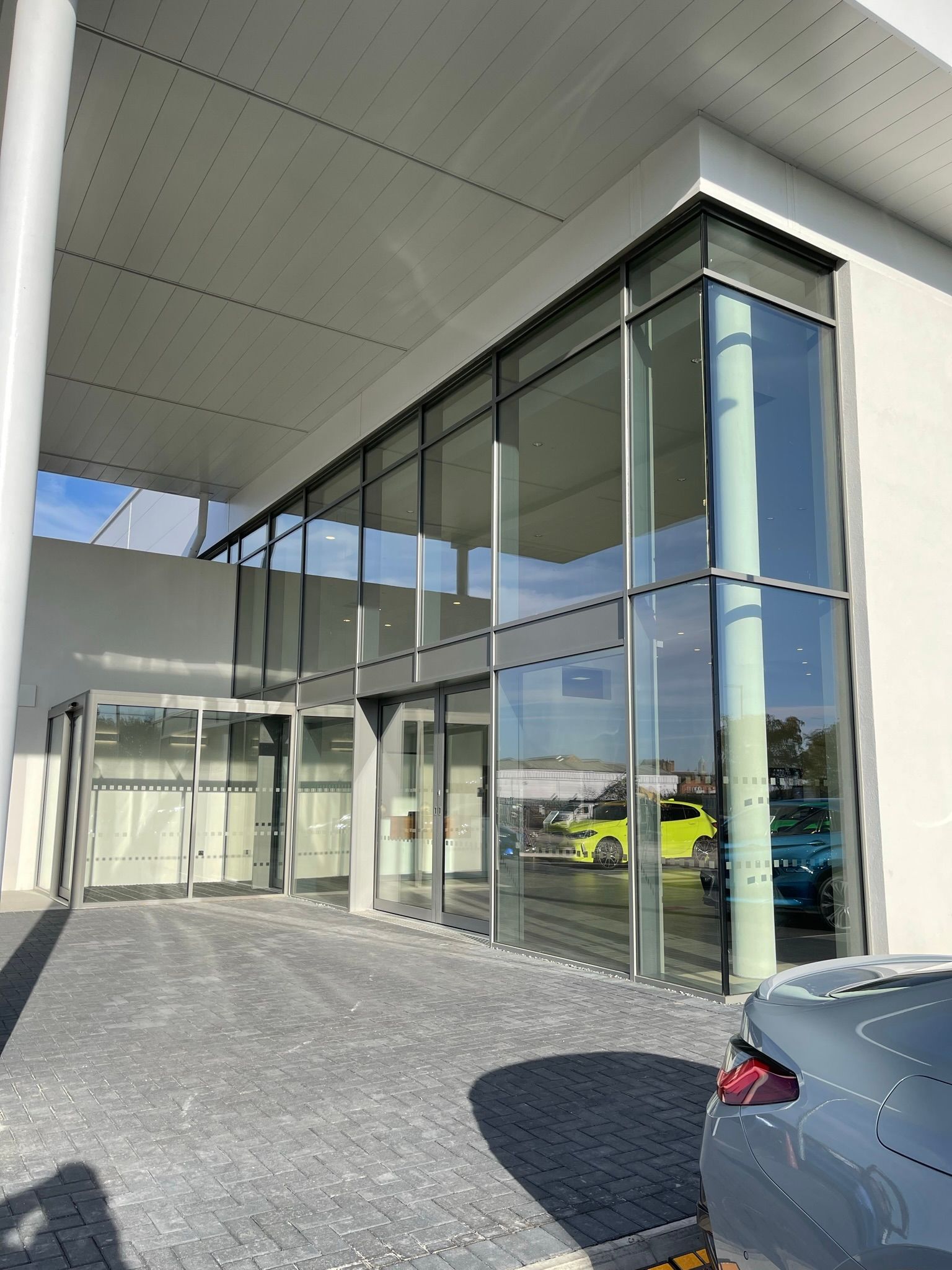 A car is parked in front of a building with a lot of windows.