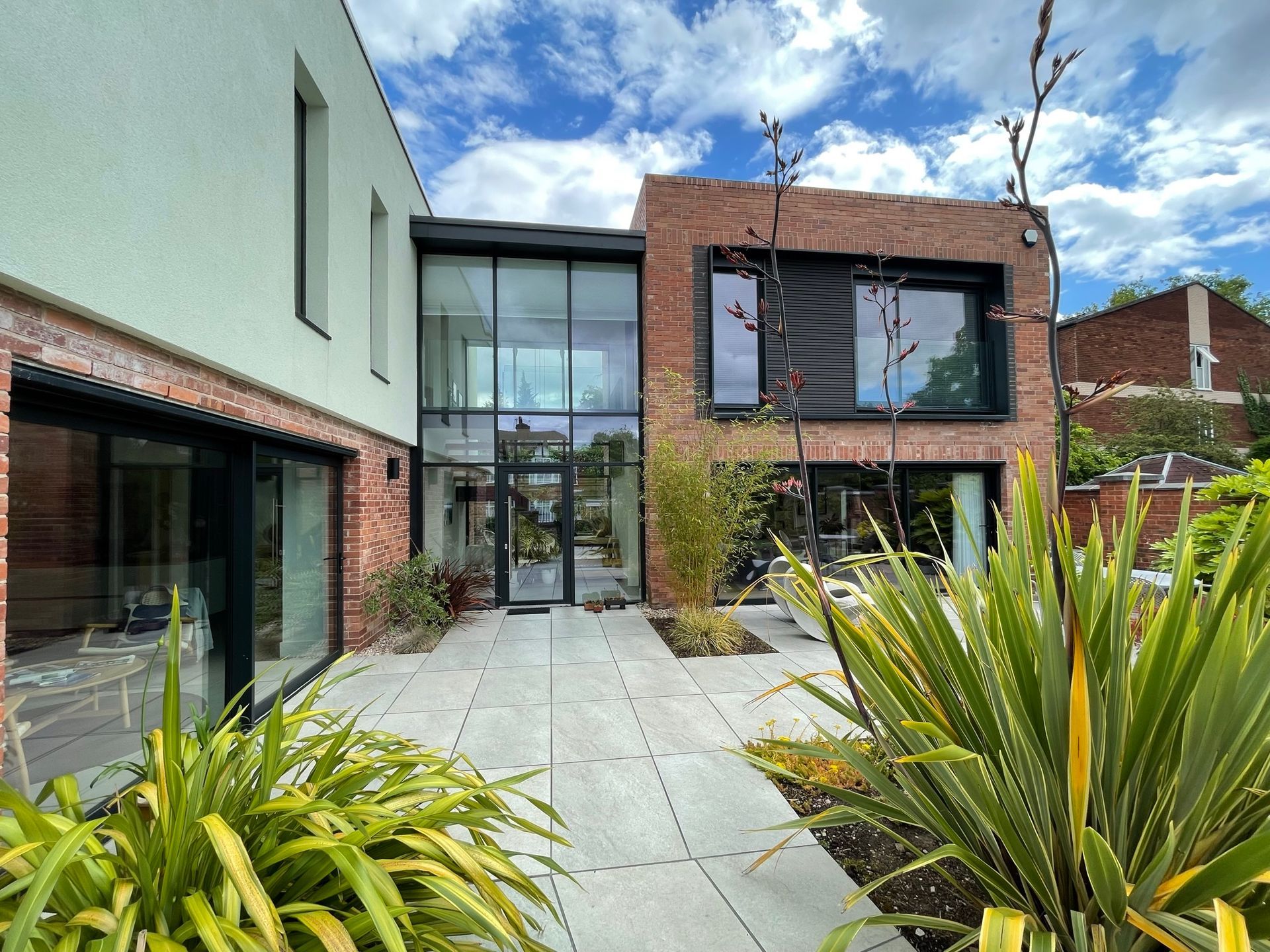 A large house with a lot of windows and plants in front of it.