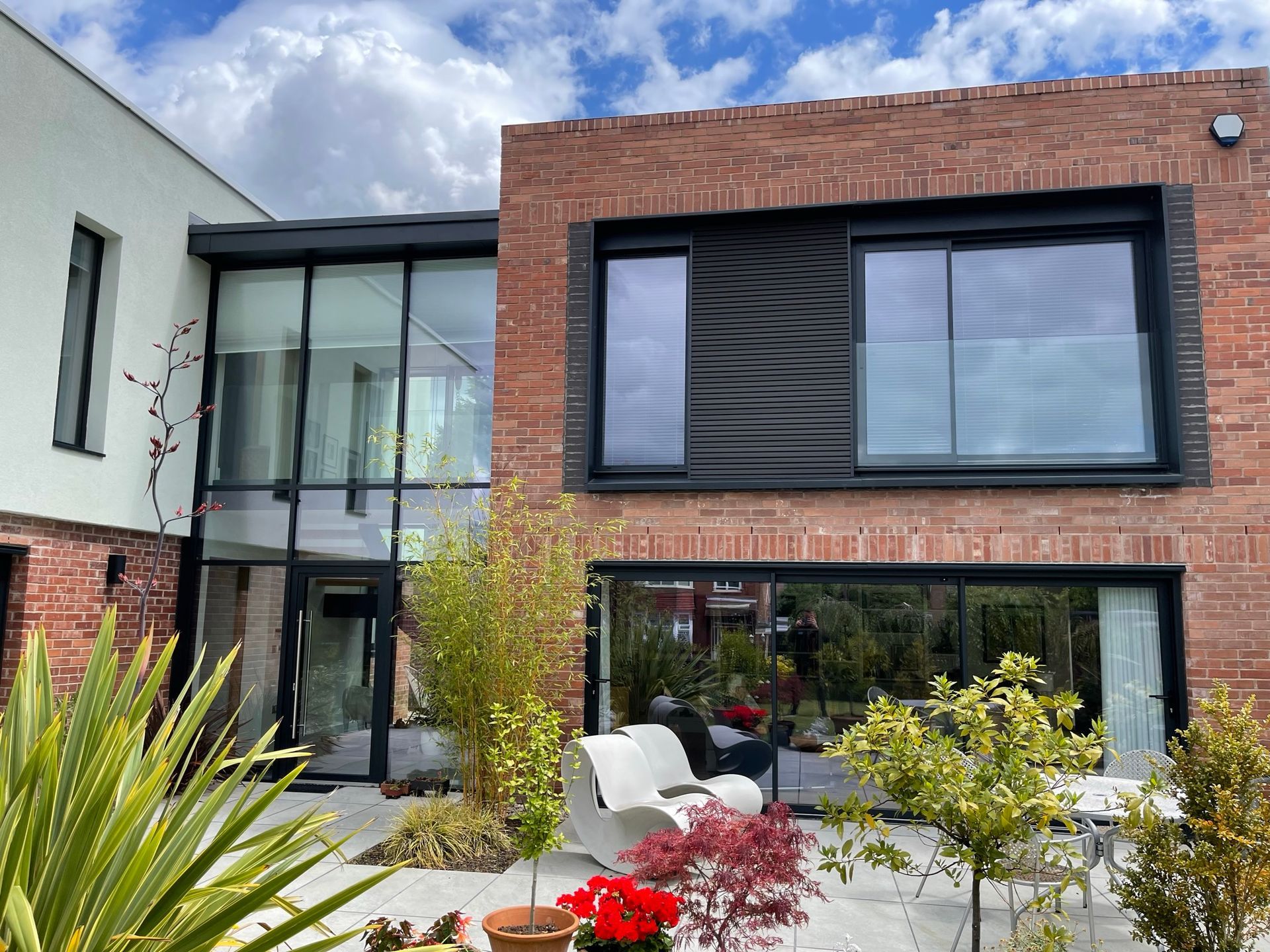 A large brick house with a lot of windows and a patio in front of it.