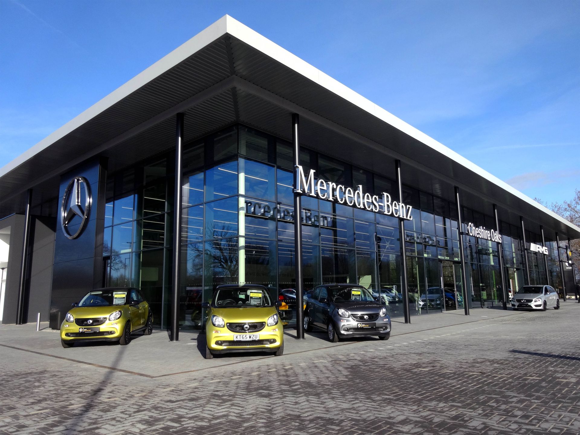 A mercedes benz dealership with cars parked in front of it