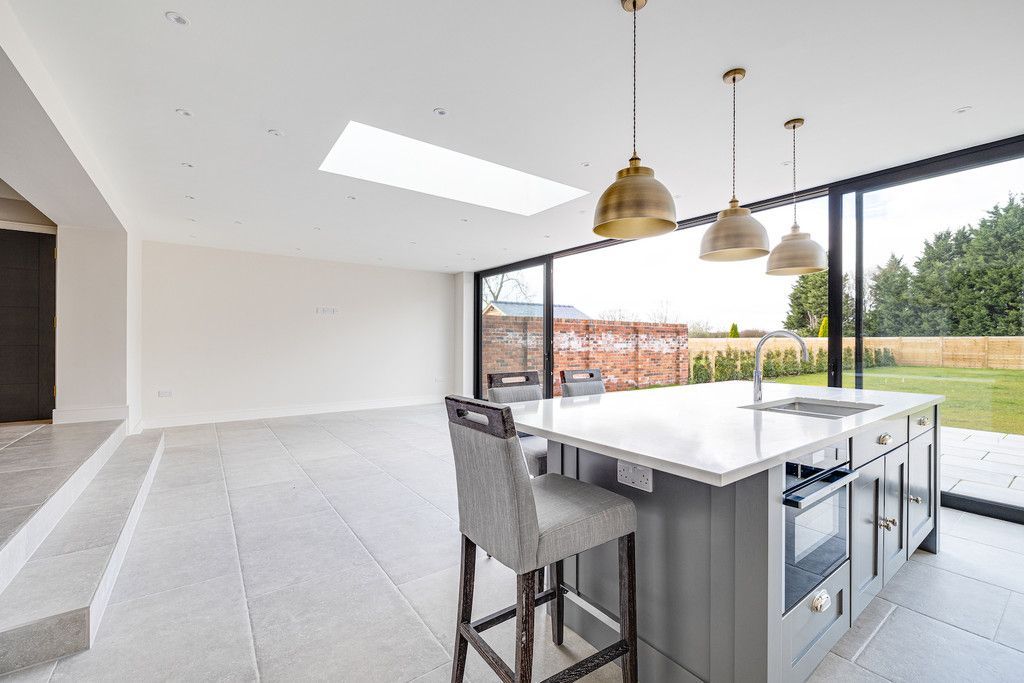 An empty kitchen with sliding glass doors and a large island.