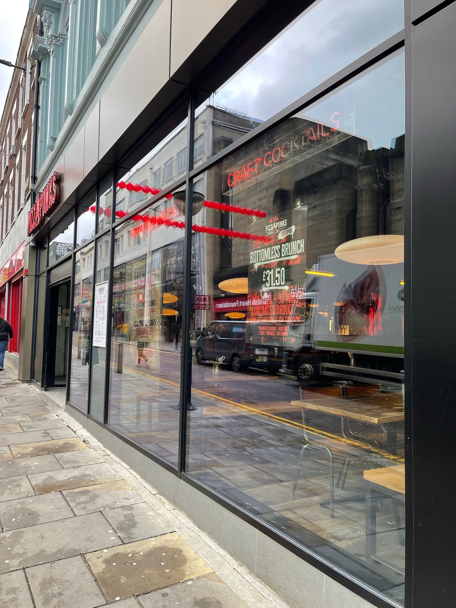 A store front with a lot of windows and a reflection of a building in the windows.