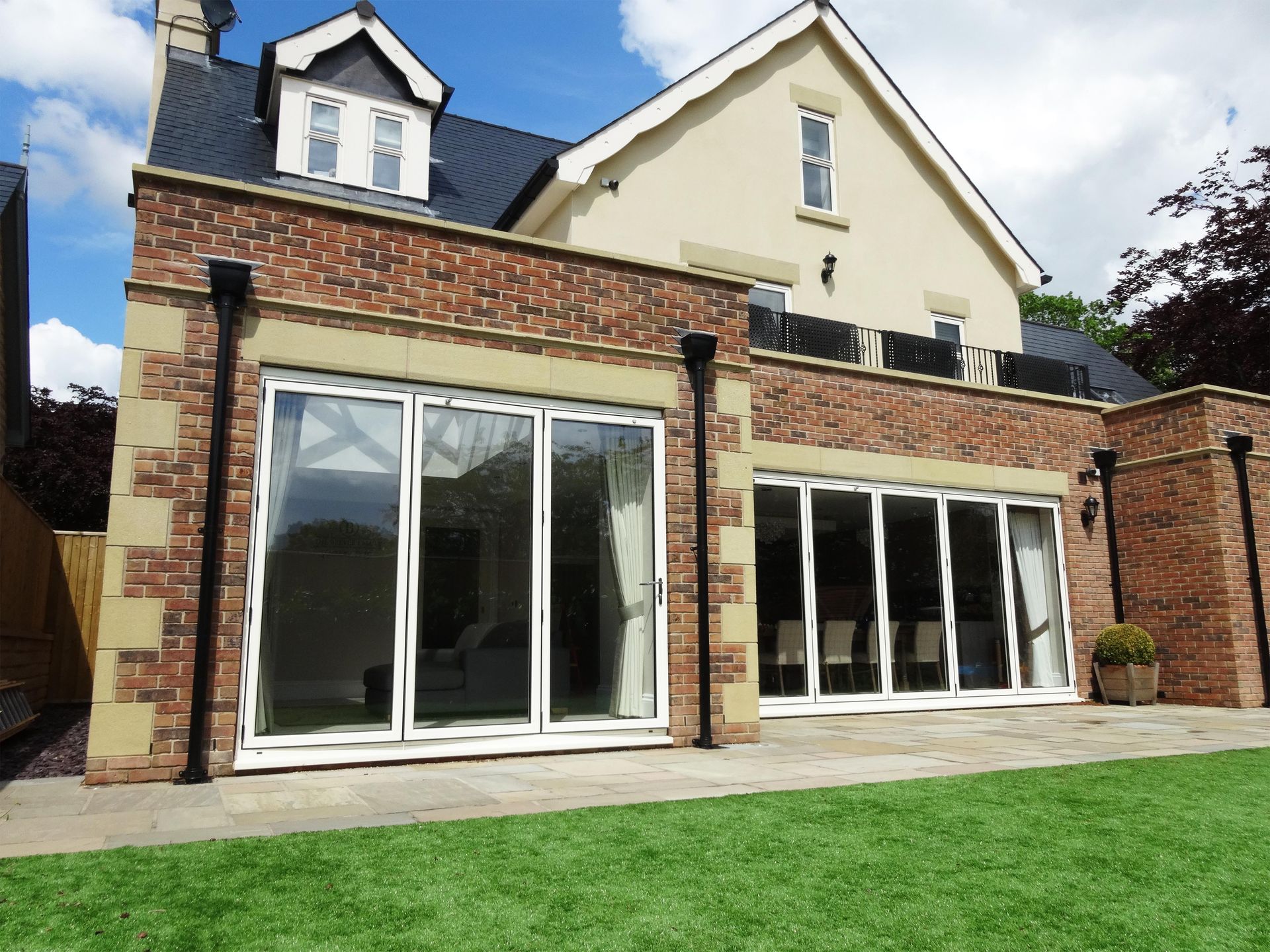A large house with a lot of windows and a lawn in front of it
