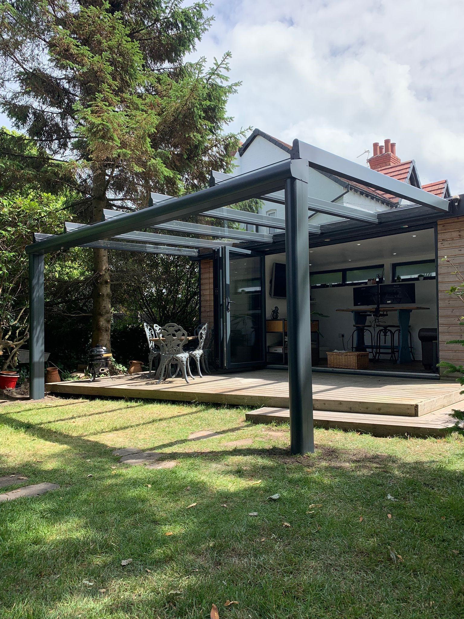There is a pergola in the backyard of a house.