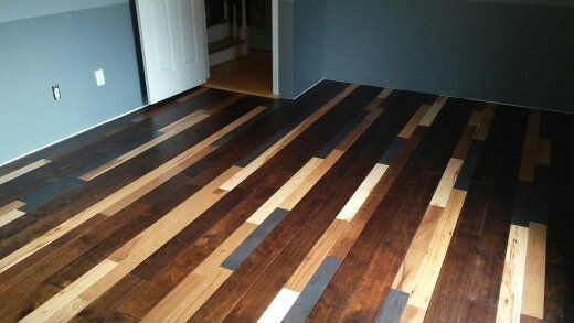 Diagonal hardwood floor with varying wood tones in a room with blue walls.