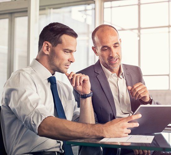 Businessmen Working on Digital Tablet — Brooklyn, NY — BATISTA & ASSOCIATES CORP.