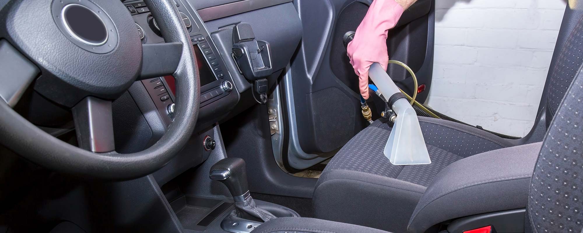 Automobile upholstery being cleaned by vacuum