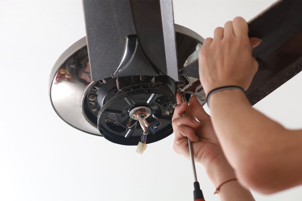Person Attaching a Ceiling Fan Blade With a Screwdriver — Ionspark Electrical in Dimbulah, QLD