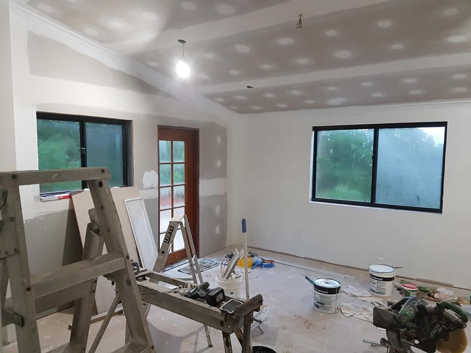 Hands Installing a Lightbulb Into a Ceiling Light Fixture — Ionspark Electrical in Atherton, QLD