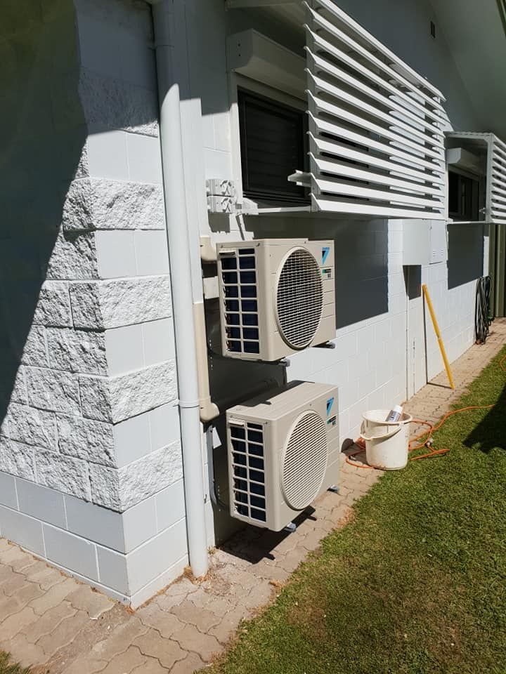 Construction in hallway with worker on ladder, dog walking, and air conditioner.— Ionspark Electrical in Atherton, QLD