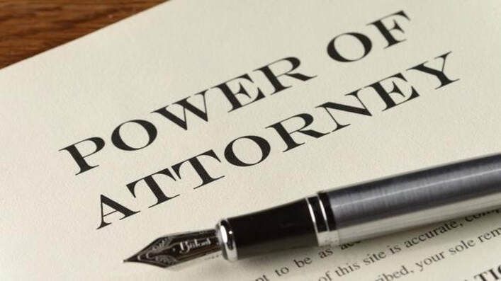 A pen is sitting on top of a power of attorney.
