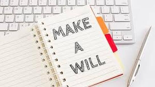 A notebook with the words `` make a will '' written on it is sitting on top of a keyboard.