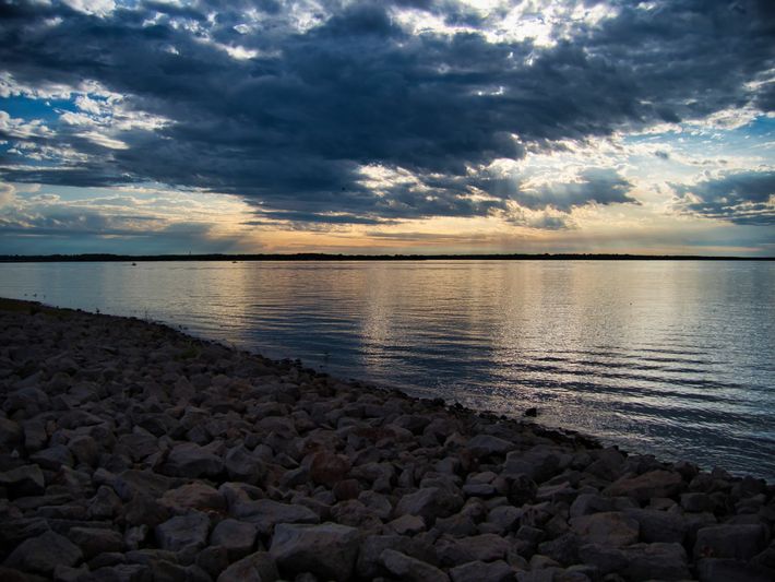 A large body of water with a cloudy sky in the background