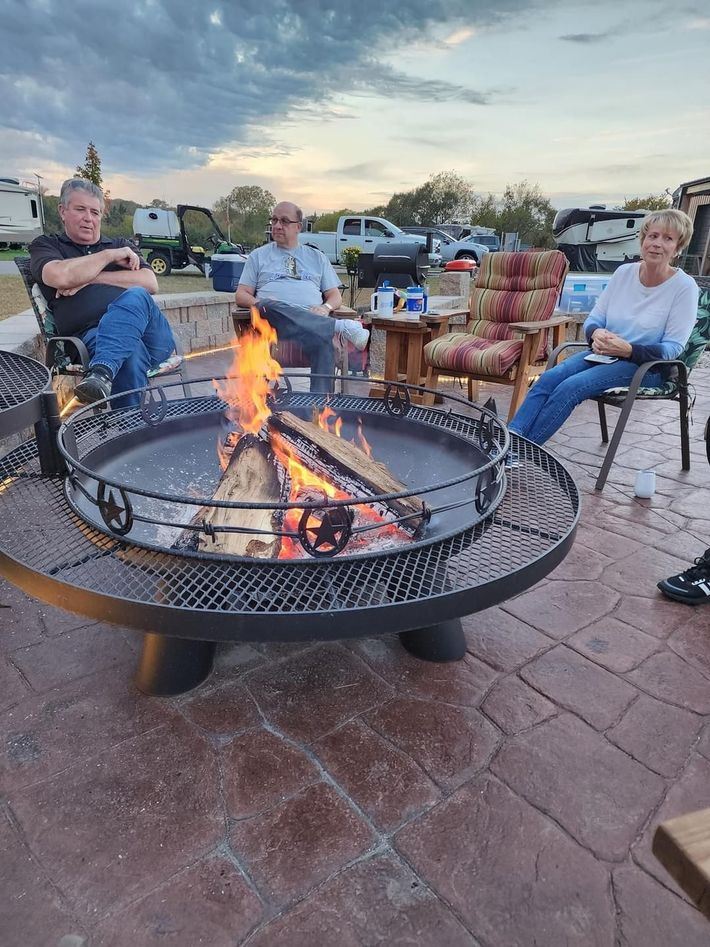 A group of people are sitting around a fire pit.