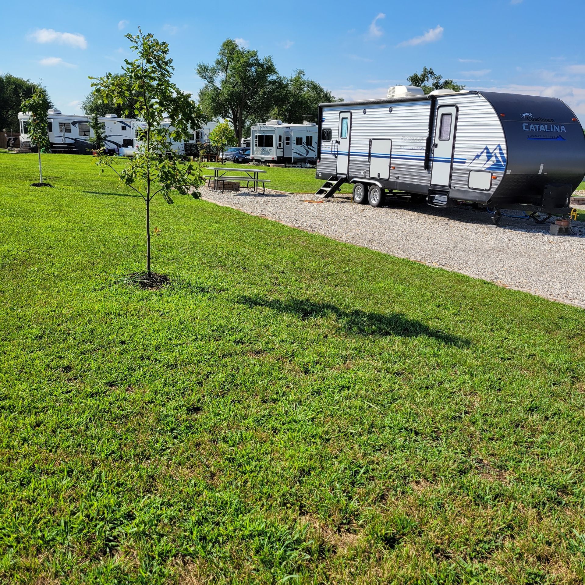 A trailer is parked in the middle of a grassy field.