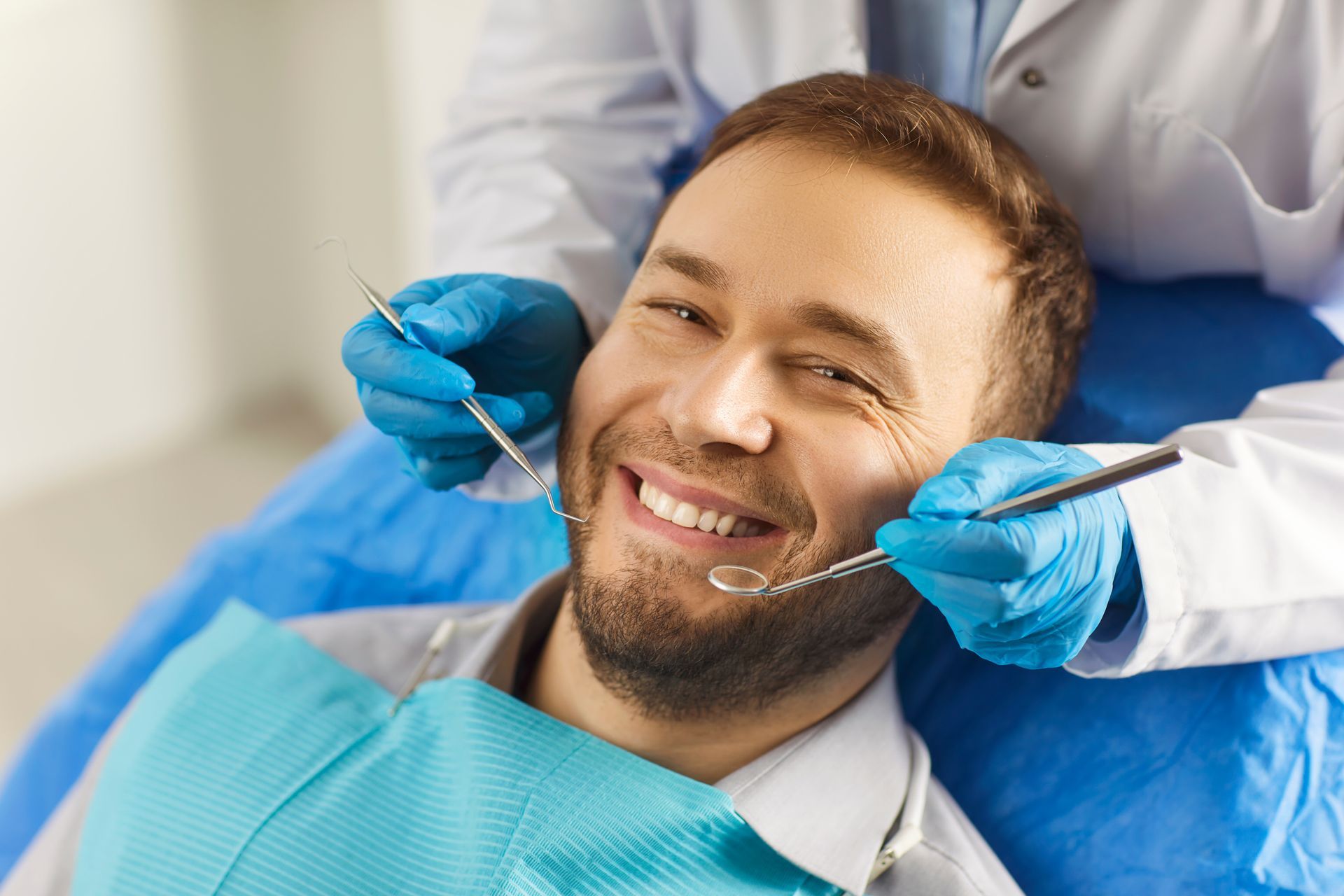 A man sits in a dentist’s chair, confidently smiling while enjoying professional dental care. A man sits in a dentist’s chair, confidently smiling while enjoying professional dental care.