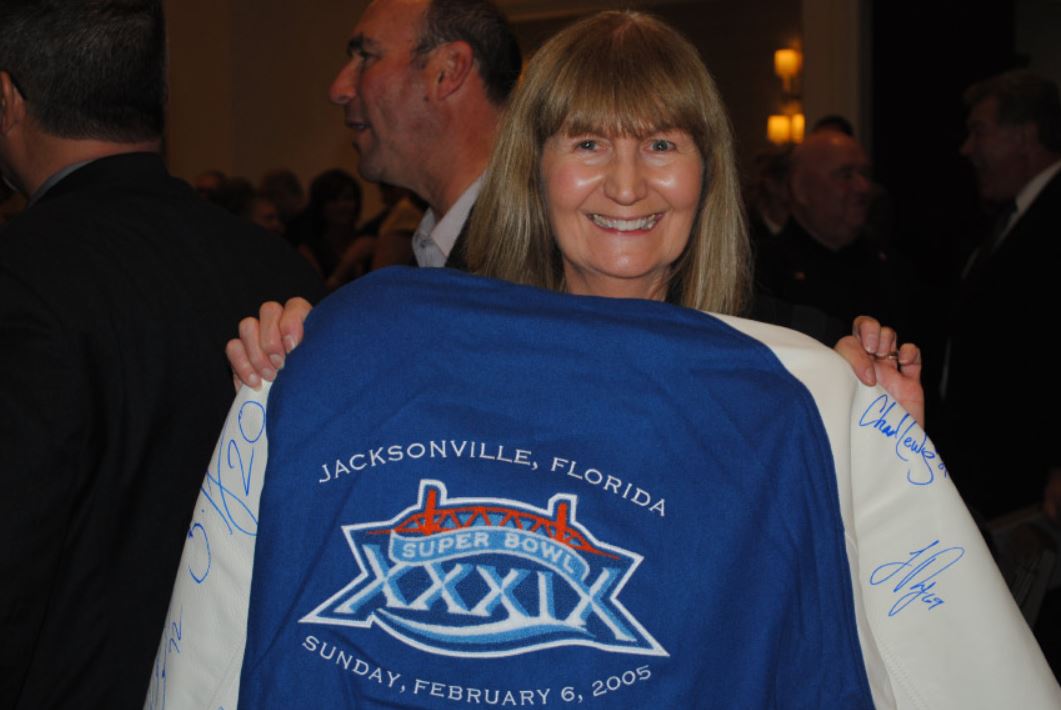 A woman is holding a blue shirt that says jacksonville florida on it
