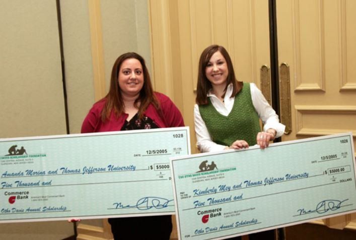 Two women holding a large check that says ' ash ' on it
