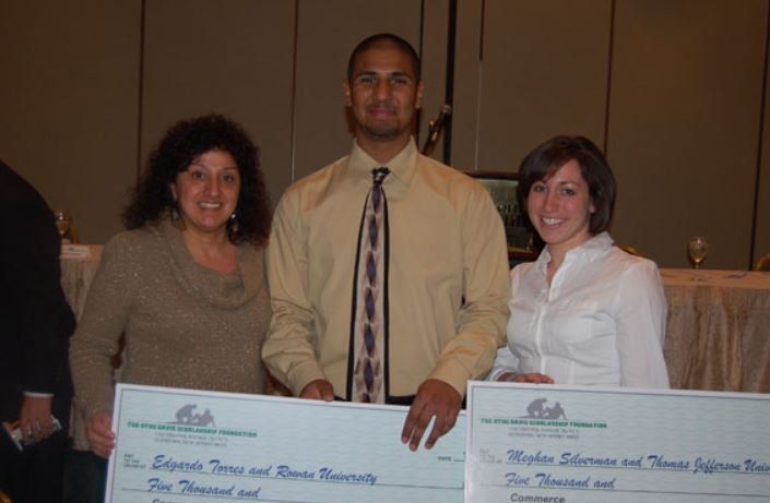 A man and two women standing next to each other holding checks