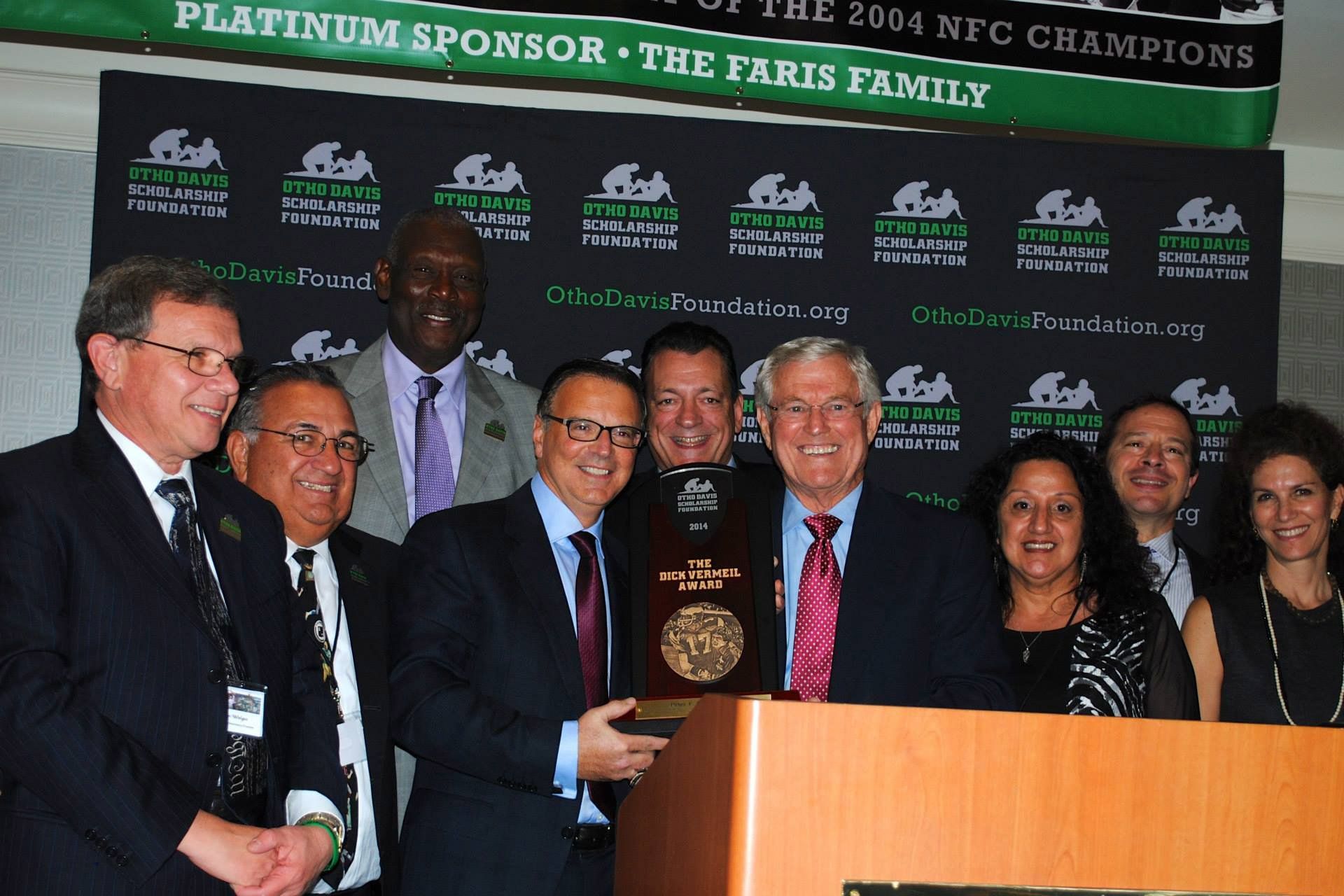 A group of people standing in front of a sign that says platinum sponsor