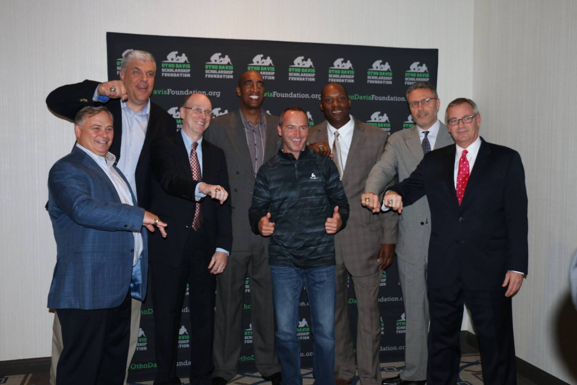 A group of men in suits and ties are posing for a picture.