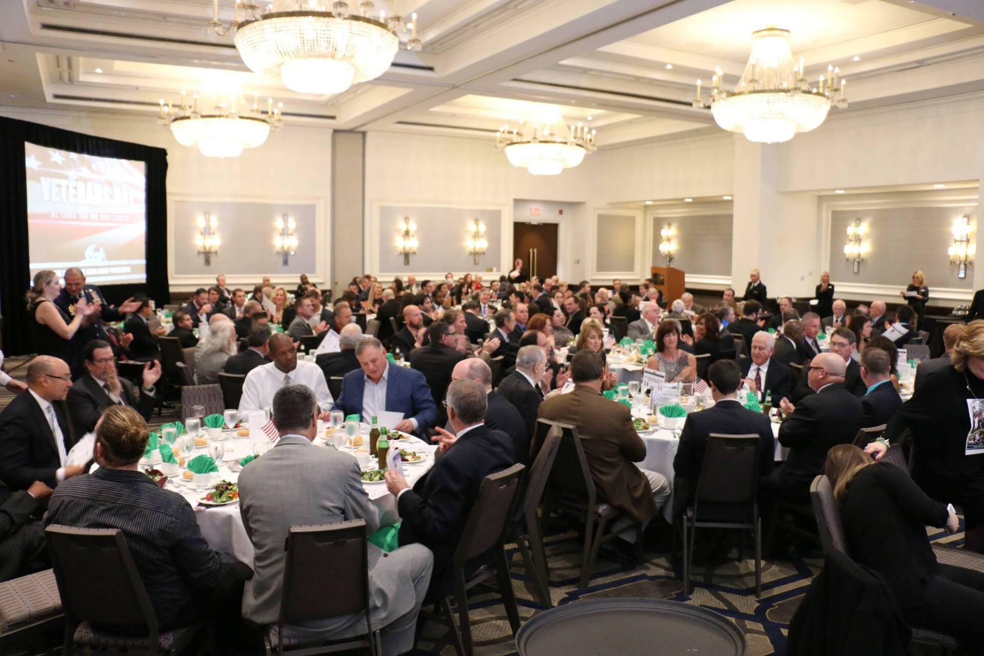 A large group of people are sitting at tables in a large room.