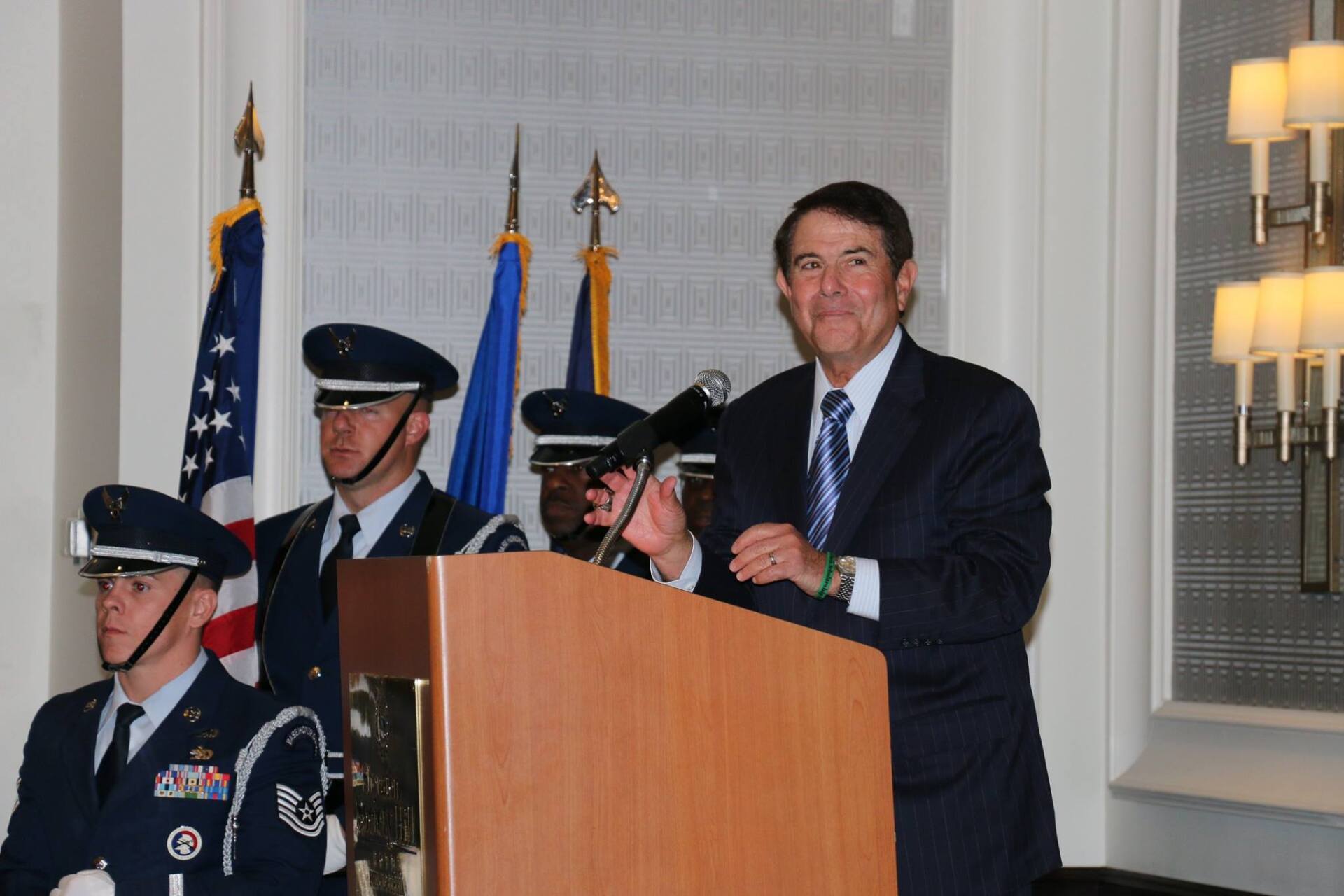 A man in a suit and tie is standing at a podium giving a speech