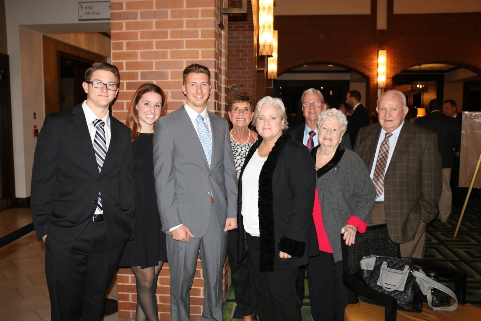 A group of people posing for a picture in front of a brick wall