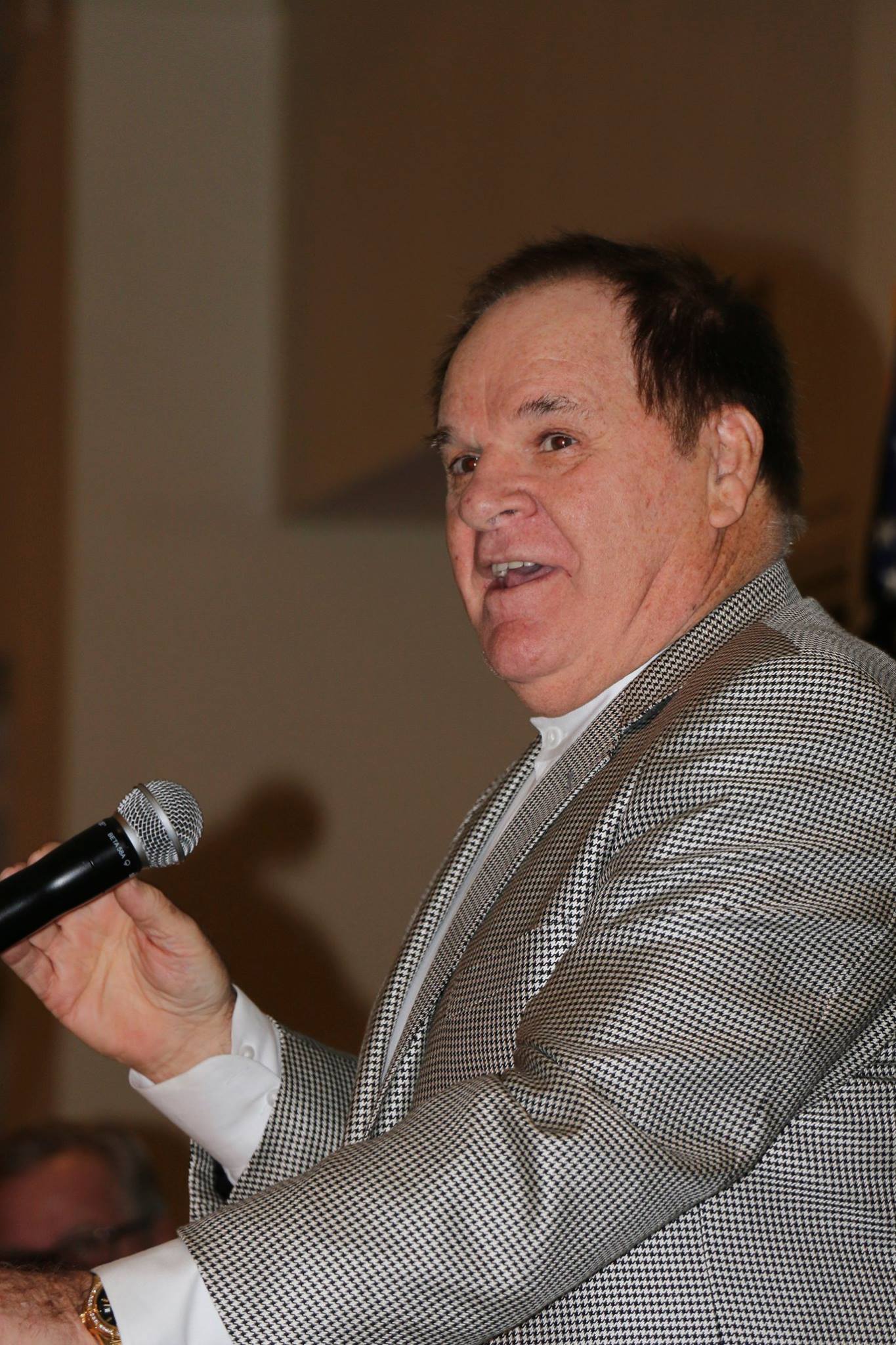 A man in a suit is holding a microphone in his hand.