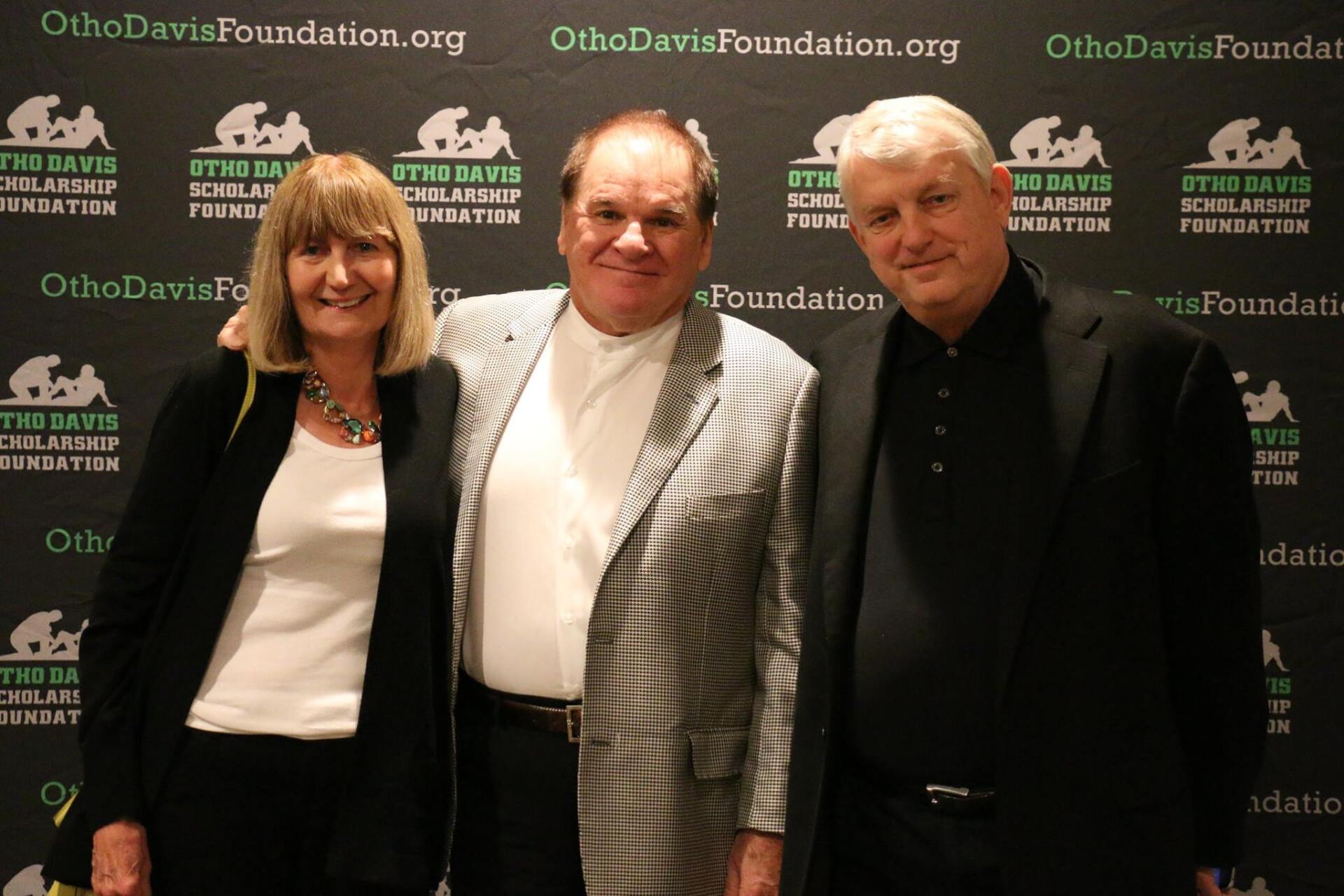 Three people are posing for a picture in front of a wall that says ohio davis foundation