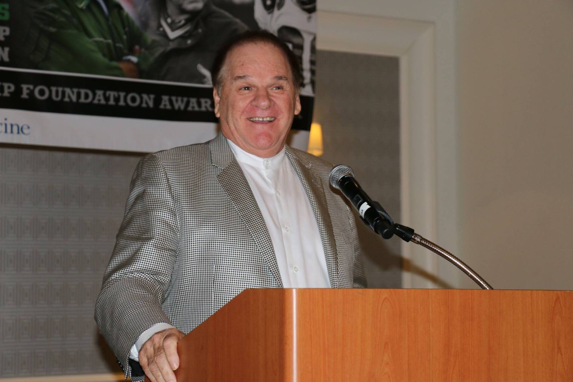 A man stands at a podium in front of a sign that says foundation award