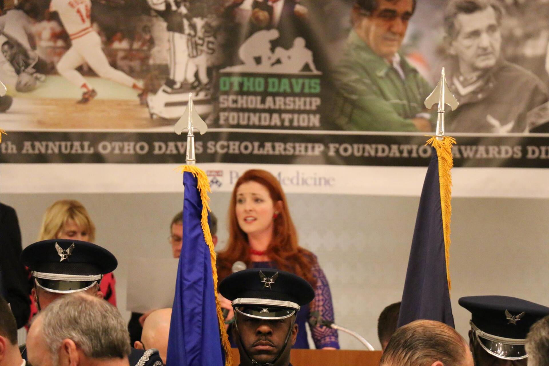 A woman stands at a podium in front of a banner that says otnb davis scholarship foundation