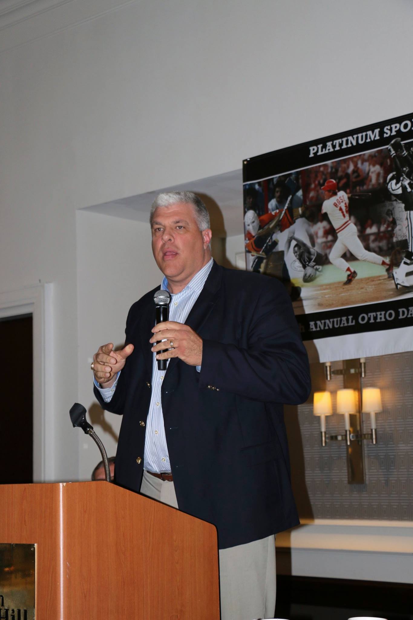 A man is standing at a podium speaking into a microphone