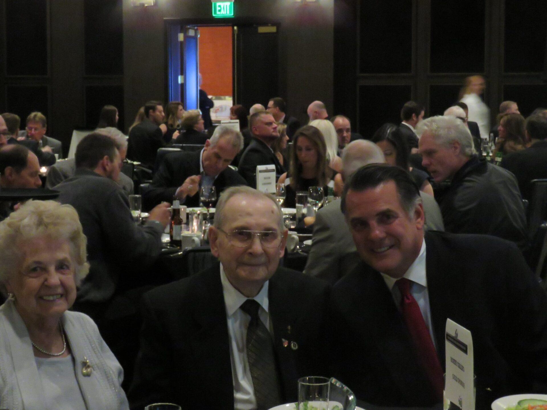A group of people are sitting at tables in a dark room